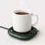 Donkergroene mokverwarmer met koffie op lichtgrijze achtergrond